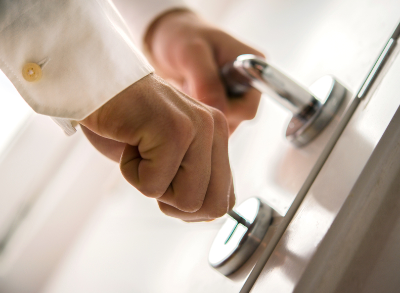 Hands inserting keys in door lock